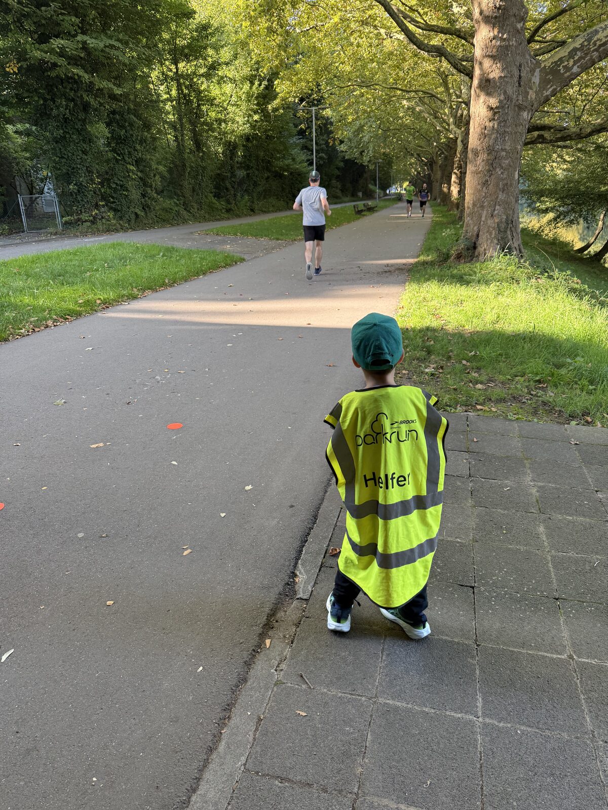 Junger Helfer in Warnweste an der parkrun-Strecke